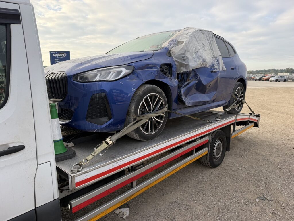 Accident-damaged BMW collected from an auction yard on a Recovery Car flatbed