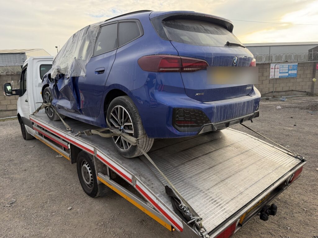 Auction car transport: BMW loaded on a flatbed recovery truck, London