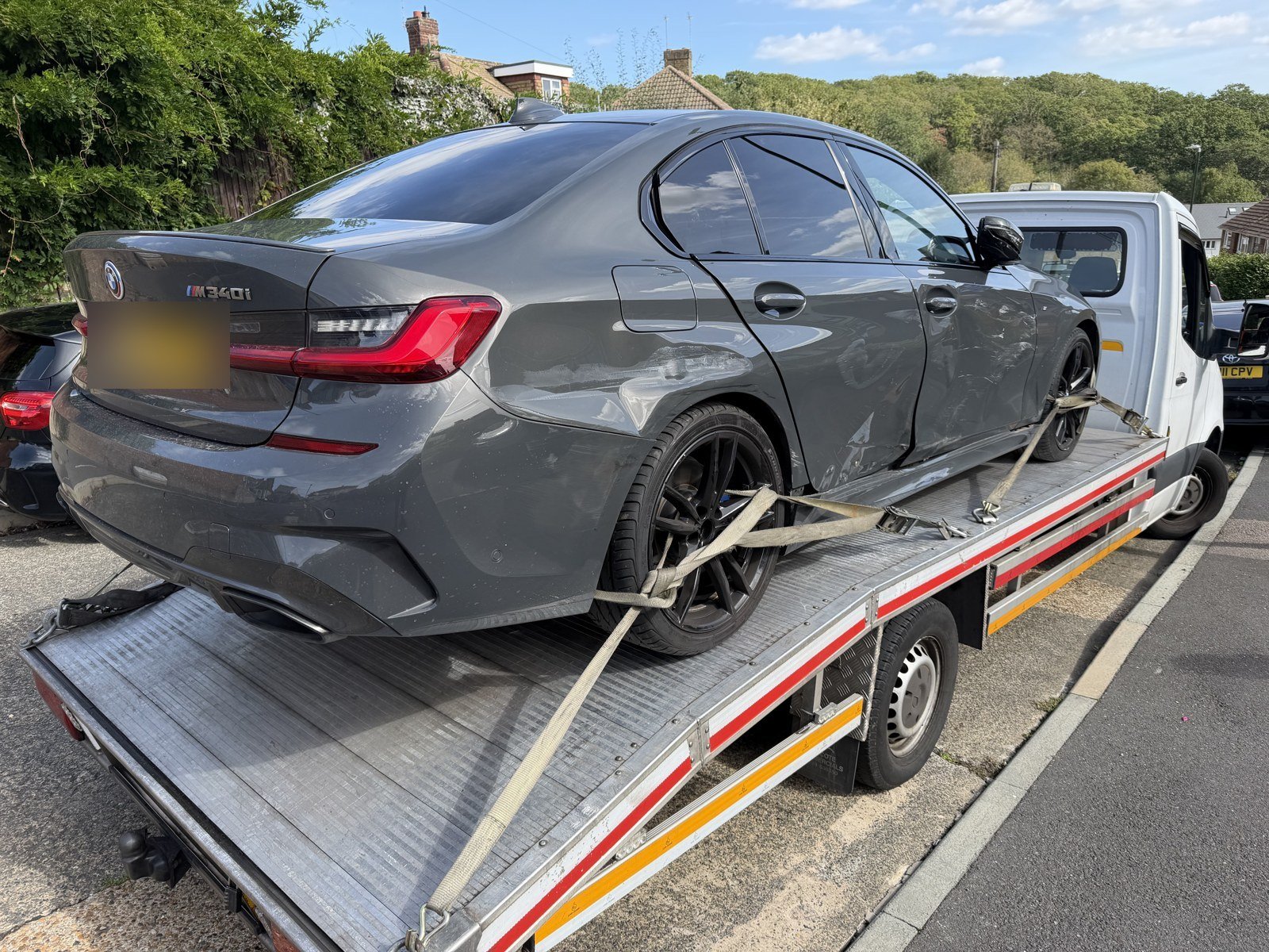 Broken Down Right Outside Your House? We Still Come to You 1 Accident-damaged BMW secured on a flatbed recovery truck in South East London