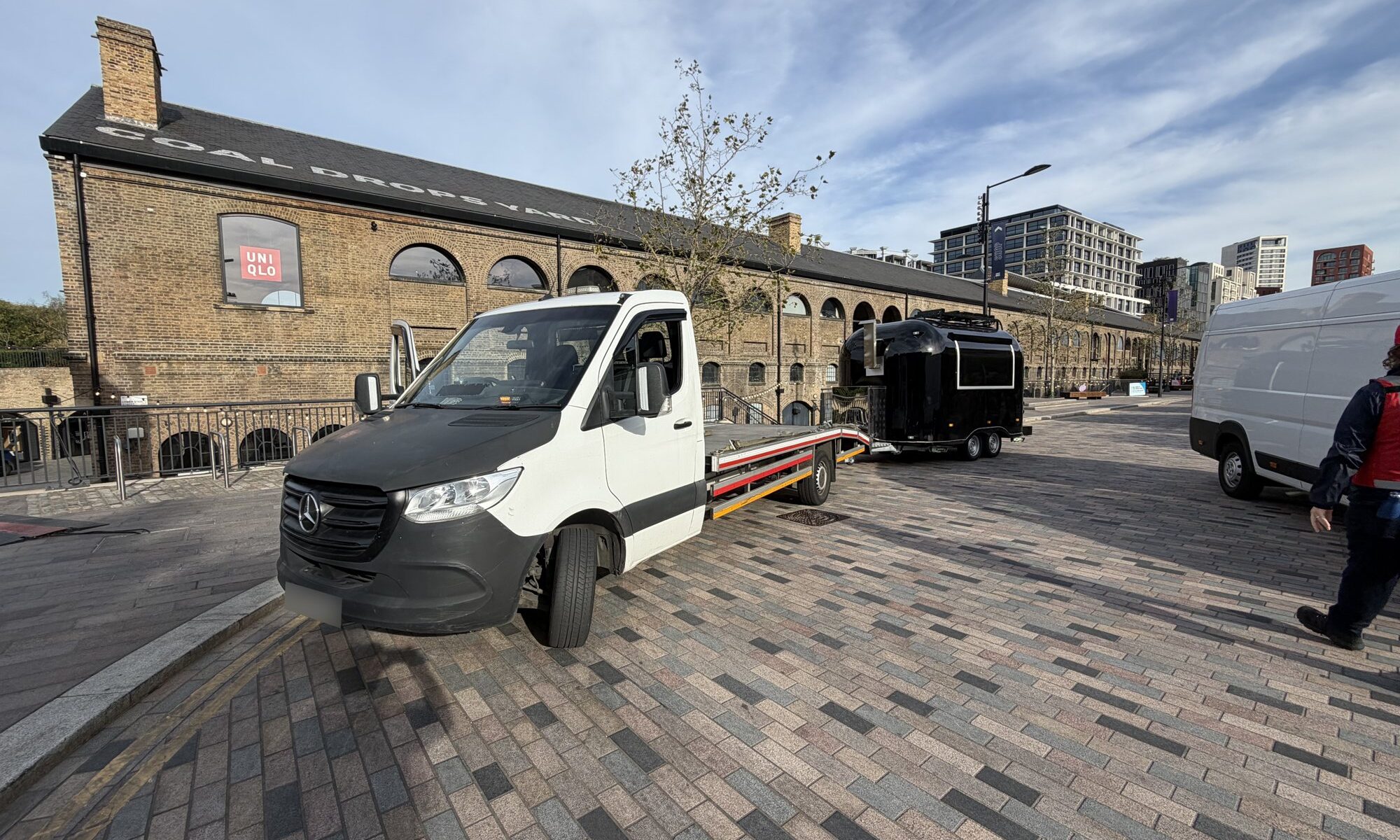RecoveryCar flatbed truck transporting a food trailer in King's Cross, London
