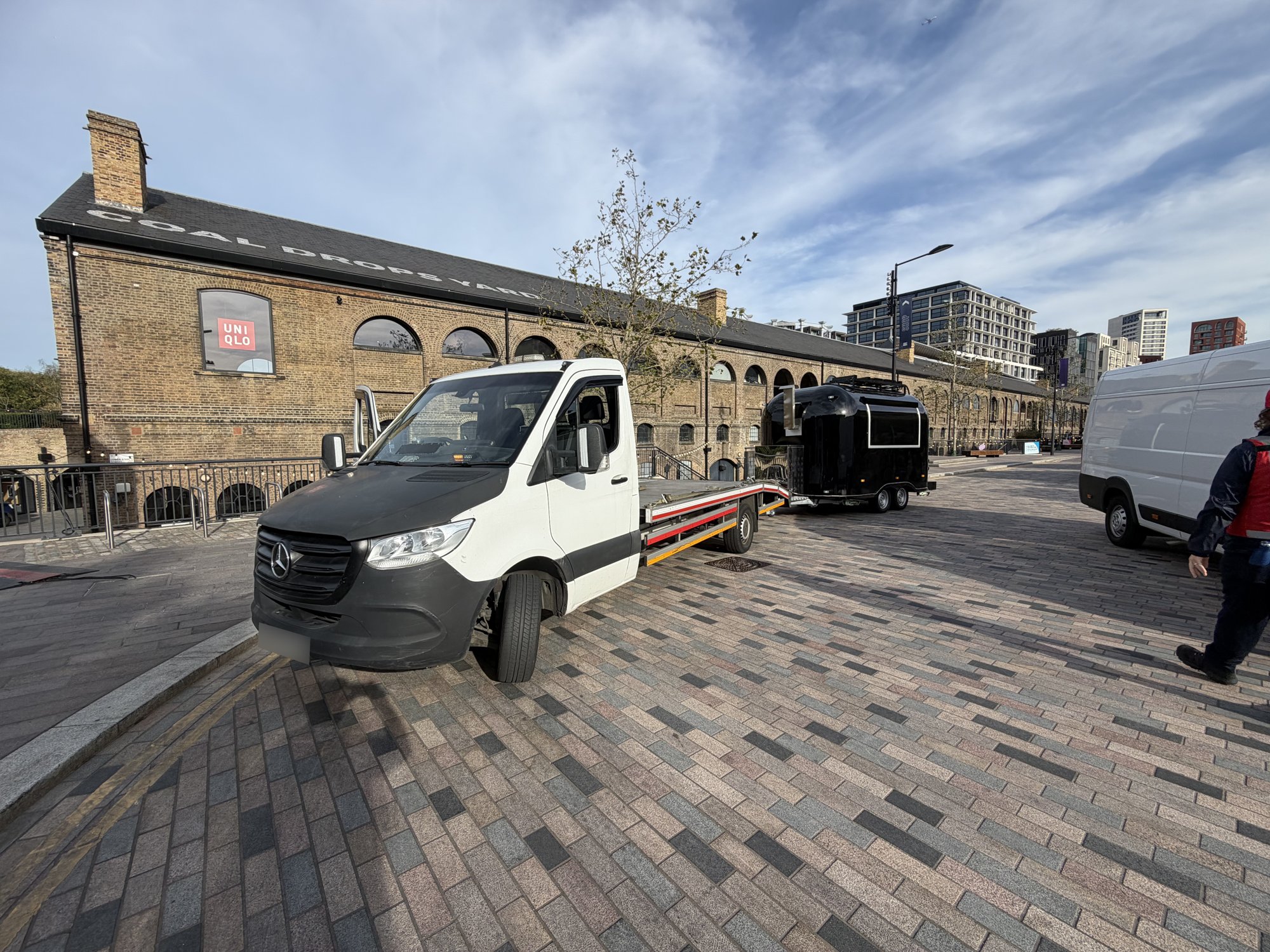 RecoveryCar flatbed truck transporting a food trailer in King's Cross, London
