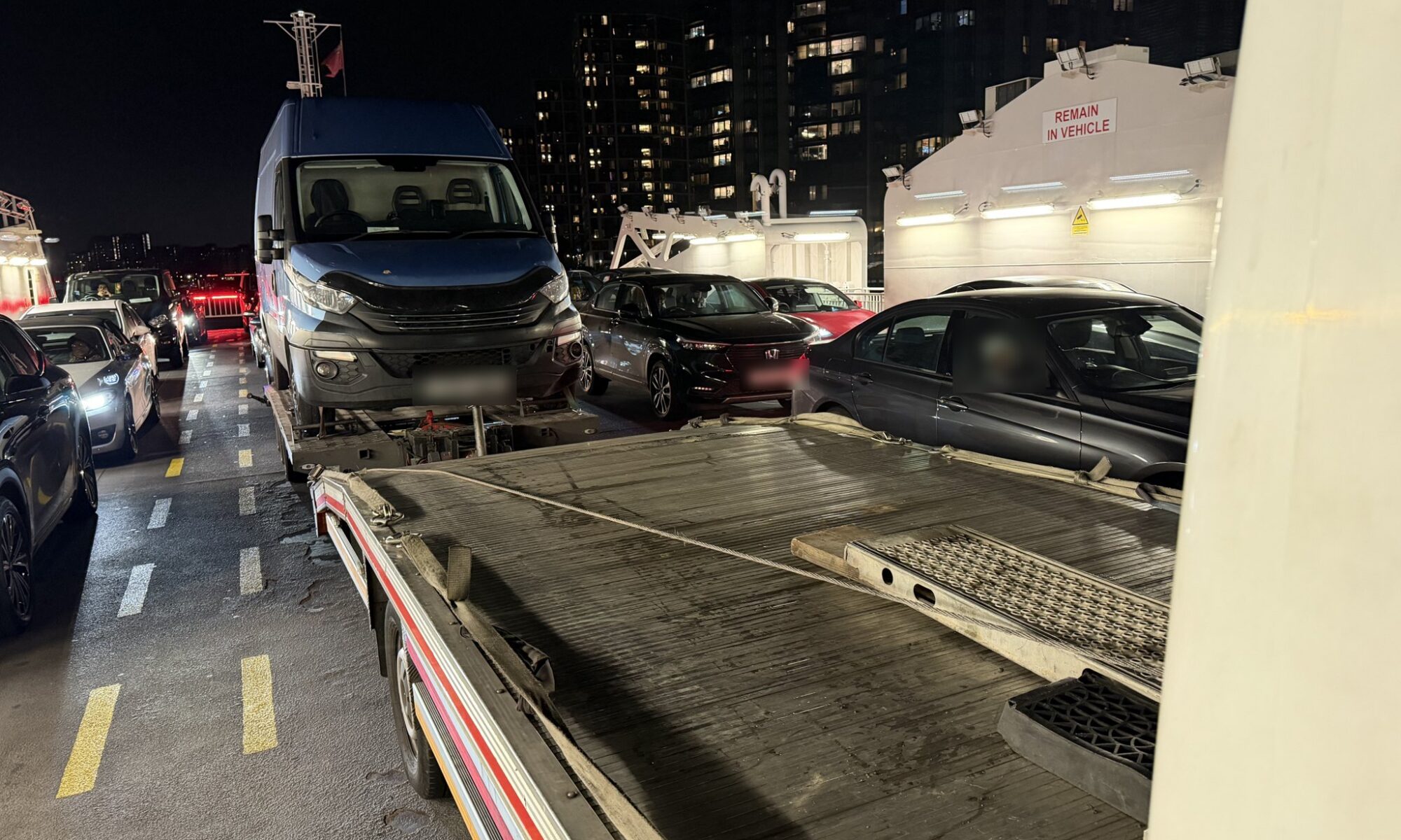 Van towing across the Woolwich Ferry at night - Iveco Daily on a RecoveryCar flatbed